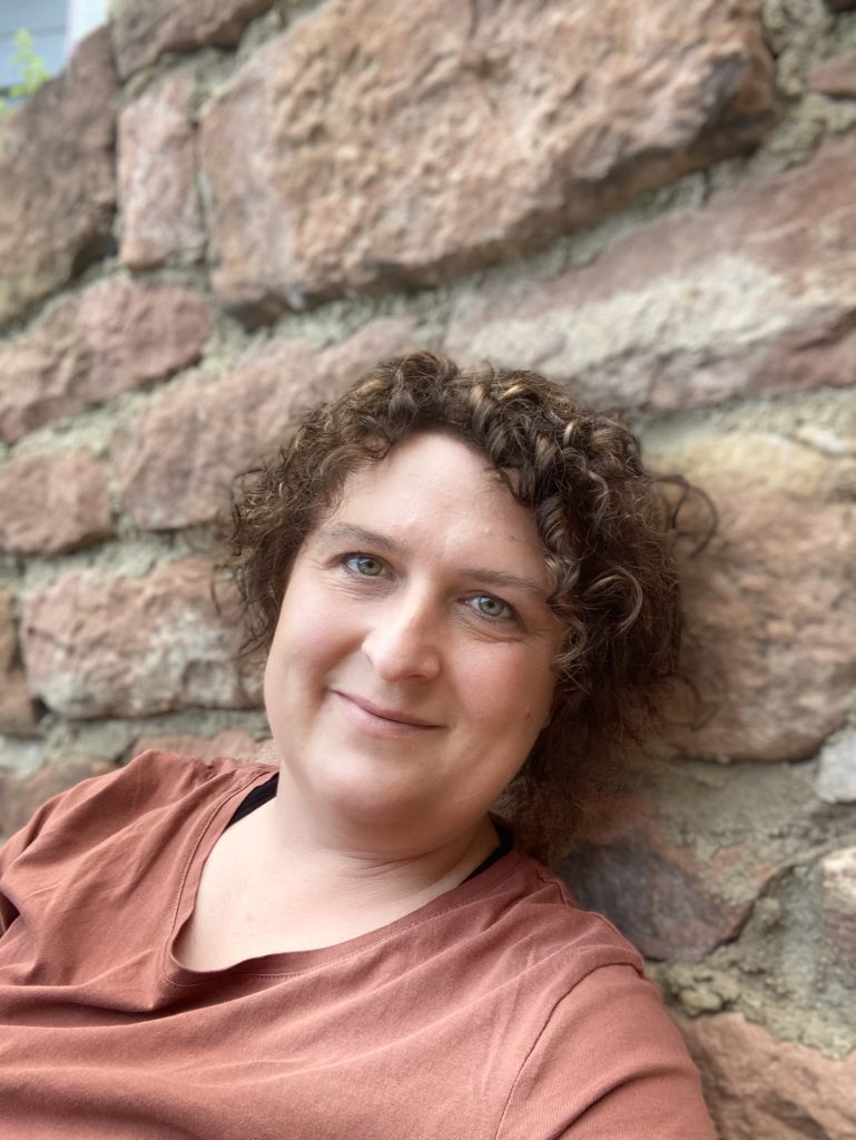 Isabell Brand vor Sandsteinmauer